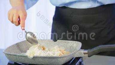 一个女人正在煎锅里用木抹子拌米粉。